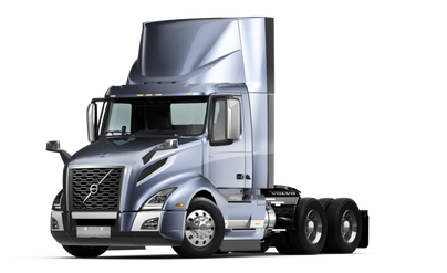 Silver semi-truck cab with aerodynamic design and large side mirrors isolated on a white background