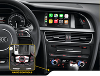 Audi car interior showing steering wheel, digital instrument panel, multimedia screen with app icons, and radio control interface.
