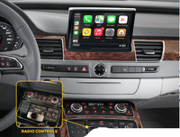 Car dashboard featuring multimedia screen with phone, maps, music apps displayed and highlighted radio control panel below