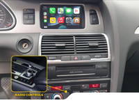 Audi car dashboard with multimedia screen showing app icons and highlighted radio control knob on center console panel