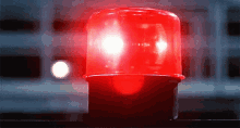 Rotating red police siren light flashing on dark background symbolizing emergency or alert situation